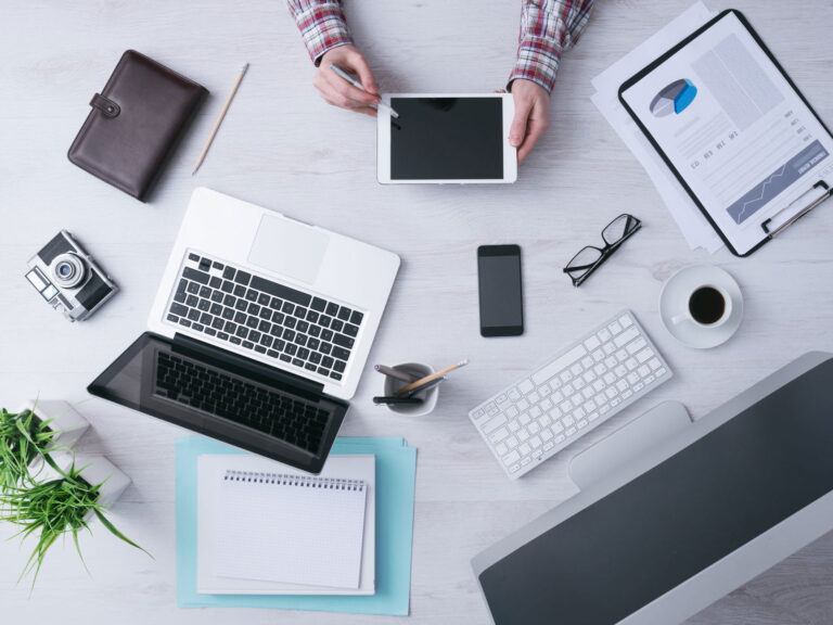 Laptop, tablet, camera, and other technology on a desk