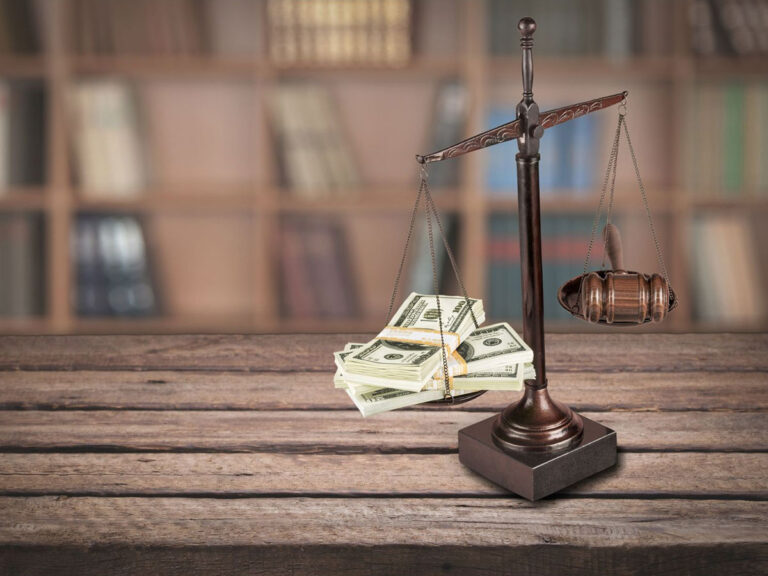 Scales with money on one side and gavel on another