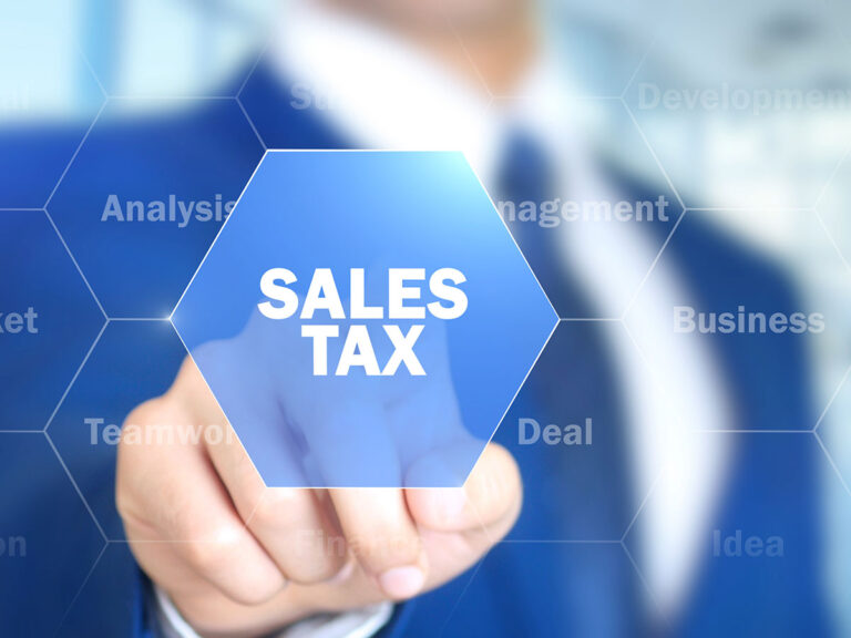 Man in business suit pointing at words sales tax