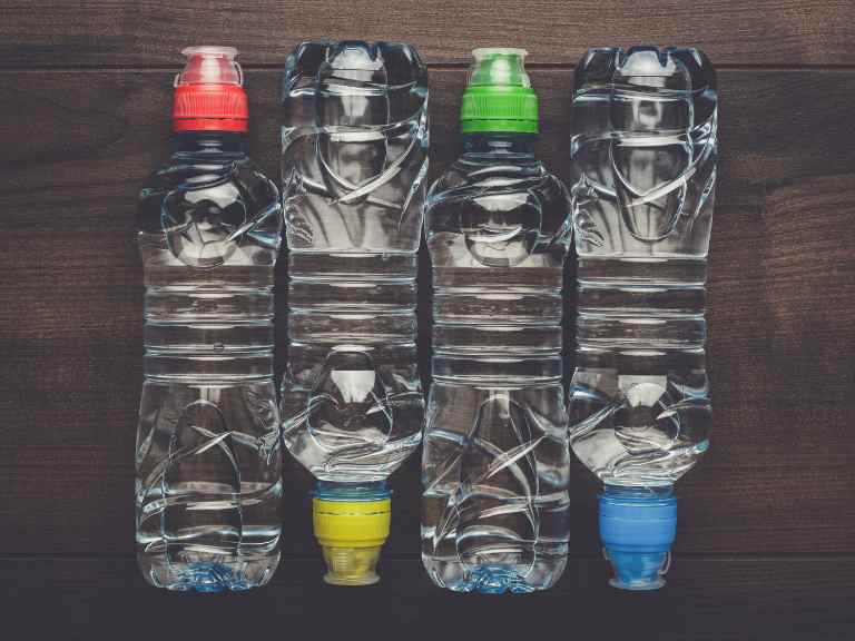 4 bottles of water on wood tabletop