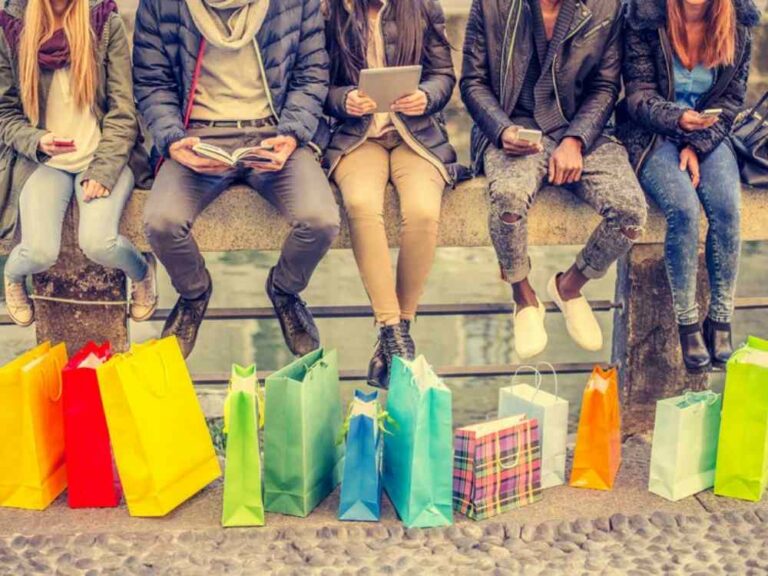 People sitting on ledge above shopping bags