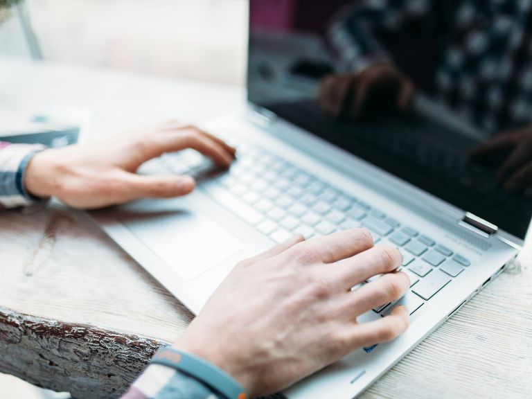 Man's hands typing on laptop